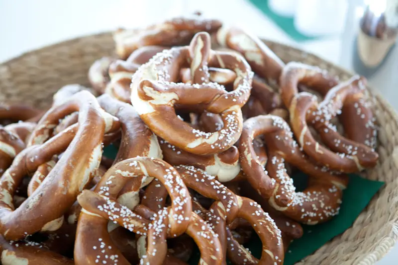 Korb voller frisch gebackener, gesalzener Laugenbrezn, gestapelt als Snack für eine Veranstaltung oder Seminarpause.