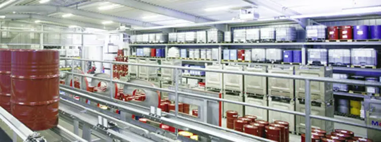 Schmierstofflager und Ölfass-Handling – sicheres Lubricant Storage im Industrieumfeld Helles Schmierstofflager mit roten Ölfässern, IBC-Containern und Regalen für industrielle Lubricants