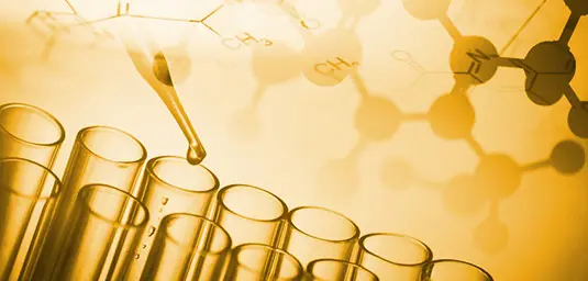 Schmierstoff-Additive und Chemie – Formulierung von Hochleistungsölen im Labor Gelb getöntes Laborbild mit Pipette über einer Reihe von Reagenzgläsern und chemischen Strukturformeln im Hintergrund
