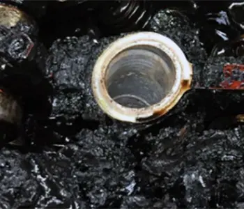 Starker schwarzer Ölschlamm und Verkokungen im Motor als extremes Schadensbild fortgeschrittener Ölalterung und überschrittener ÖllebensdauerMotorinnenraum als Beispiel für vernachlässigte Ölpflege