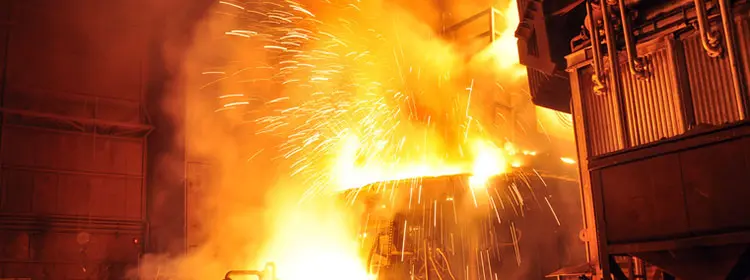 Funkenflug und flüssiger Stahl in einer heißen Industrieanlage als typische Umgebung mit hoher Brandgefahr für Hydraulikflüssigkeiten