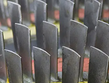 Detailaufnahme eines metallischen Turbinenrads mit vielen Schaufeln als typisches Bauteil in Kraftwerks- oder Industriegasturbinen